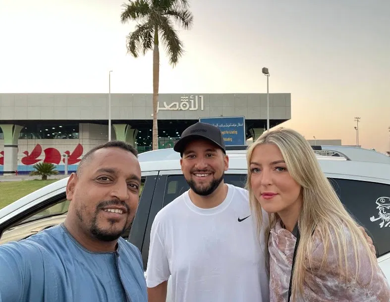 A selfie of a driver with two travellers outside Luxor Airport