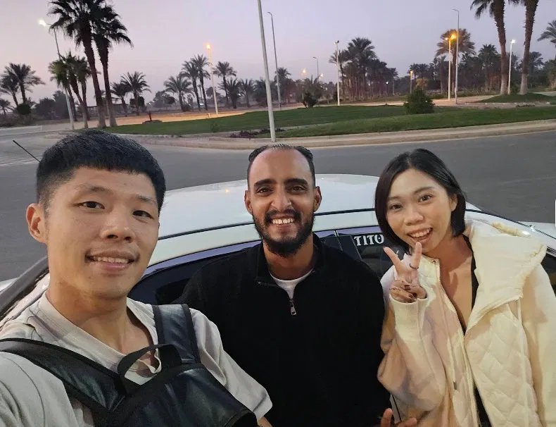 Travellers taking a sunset selfie with Tito after a tour
